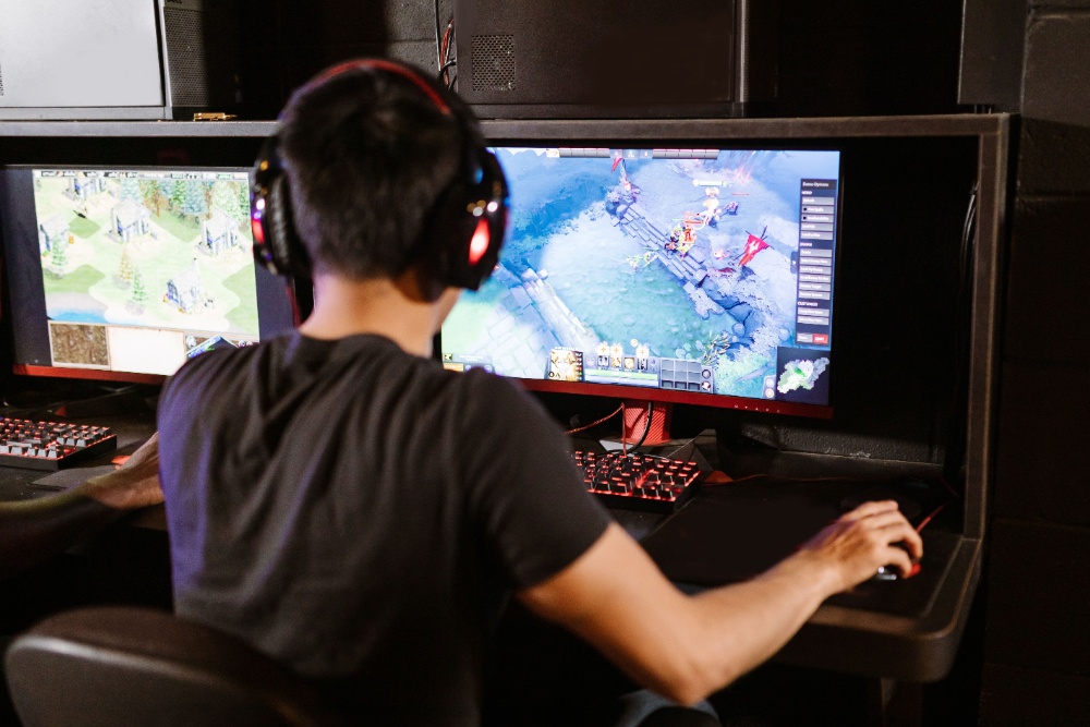 Player in a gaming chair with a headset at a dual-monitor setup, using QuickQ for a low-latency competitive route